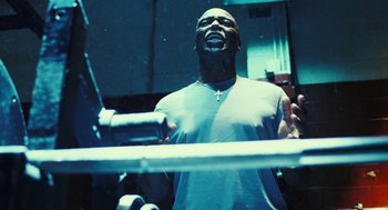 Movie still from “Rocky Balboa” (2006), directed by Sylvester Stallone – A man standing in front of a metal fence; Medium shot, Low angle