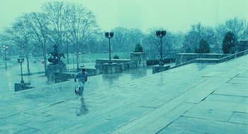 Movie still from “Rocky Balboa” (2006), directed by Sylvester Stallone – A man riding a skate board on top of a concrete path; Extreme Wide shot, High angle