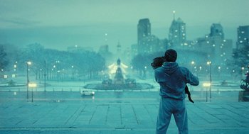 Movie still from “Rocky Balboa” (2006), directed by Sylvester Stallone – A man standing in the middle of a street in the rain; Wide shot, Over the shoulder angle