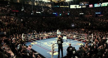 Movie still from “Rocky Balboa” (2006), directed by Sylvester Stallone – A boxing ring filled with people in a boxing ring; Extreme Wide shot, High angle
