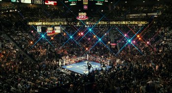 Movie still from “Rocky Balboa” (2006), directed by Sylvester Stallone – A boxing ring filled with people in the middle of a boxing ring; Extreme Wide shot, High angle