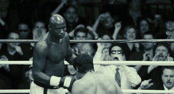 Movie still from “Rocky Balboa” (2006), directed by Sylvester Stallone – A man in a boxing ring getting ready for a fight; Medium shot, Over the shoulder angle