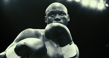 Movie still from “Rocky Balboa” (2006), directed by Sylvester Stallone – A black and white photo of a man wearing boxing gloves; Close Up shot, Low angle