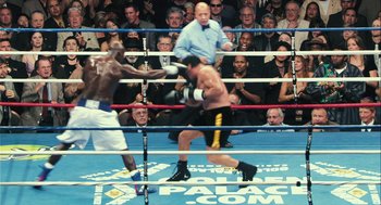 Movie still from “Rocky Balboa” (2006), directed by Sylvester Stallone – Two boxers in a boxing ring during a match; Wide shot, Over the shoulder angle