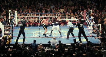Movie still from “Rocky Balboa” (2006), directed by Sylvester Stallone – A boxing match in a boxing ring with spectators watching it; Extreme Wide shot, High angle