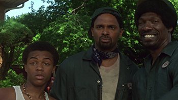 Movie still from “Roll Bounce” (2005), directed by Malcolm D. Lee – A man and a boy standing next to each other in front of trees; Close Up shot, Low angle
