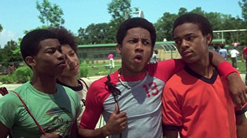 Movie still from “Roll Bounce” (2005), directed by Malcolm D. Lee – A group of young men standing next to each other on a field; Medium shot, Low angle