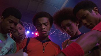 Movie still from “Roll Bounce” (2005), directed by Malcolm D. Lee – A group of young men standing next to each other in front of lights; Close Up shot, Low angle
