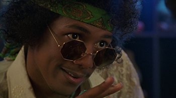 Movie still from “Roll Bounce” (2005), directed by Malcolm D. Lee – A man wearing a hat and sunglasses with his hand up to his face; Close Up shot, Low angle