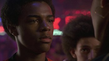 Movie still from “Roll Bounce” (2005), directed by Malcolm D. Lee – A young man and a young man standing next to each other in front of lights; Close Up shot, Low angle