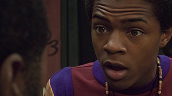 Movie still from “Roll Bounce” (2005), directed by Malcolm D. Lee – A young man with a surprised look on his face; Close Up shot, Over the shoulder angle