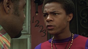 Movie still from “Roll Bounce” (2005), directed by Malcolm D. Lee – A young black man in a red and purple shirt is talking to another young black man; Close Up shot, Low angle