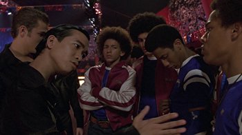 Movie still from “Roll Bounce” (2005), directed by Malcolm D. Lee – A group of young men standing next to each other; Medium shot, Over the shoulder angle
