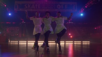 Movie still from “Roll Bounce” (2005), directed by Malcolm D. Lee – A group of people on roller blades on a stage; Wide shot, Low angle