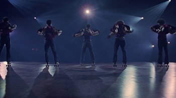 Movie still from “Roll Bounce” (2005), directed by Malcolm D. Lee – A group of young men riding roller blades on top of a floor; Wide shot, Low angle