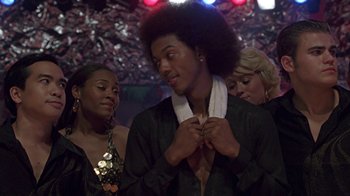 Movie still from “Roll Bounce” (2005), directed by Malcolm D. Lee – A group of young people standing in a room; Medium shot, Low angle