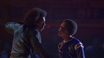 Movie still from “Roll Bounce” (2005), directed by Malcolm D. Lee – Two young men talking to each other in a dark room; Medium shot, Low angle