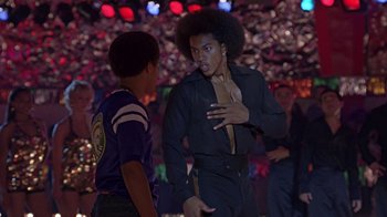 Movie still from “Roll Bounce” (2005), directed by Malcolm D. Lee – Two young men talking to each other in front of a crowd of onlookers; Medium shot, Low angle