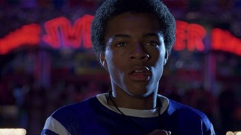 Movie still from “Roll Bounce” (2005), directed by Malcolm D. Lee – A young man with headphones in front of a neon sign; Close Up shot, Low angle