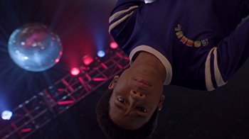 Movie still from “Roll Bounce” (2005), directed by Malcolm D. Lee – A man standing in front of a disco ball; Close Up shot, Low angle