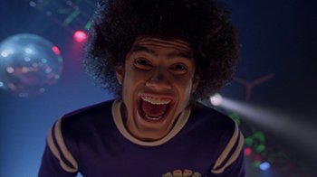 Movie still from “Roll Bounce” (2005), directed by Malcolm D. Lee – A man with a black afro is smiling for the camera; Close Up shot, Low angle