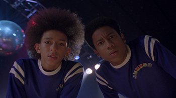 Movie still from “Roll Bounce” (2005), directed by Malcolm D. Lee – A couple of men standing next to each other; Close Up shot, Low angle