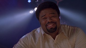 Movie still from “Roll Bounce” (2005), directed by Malcolm D. Lee – A person smiling at the camera; Close Up shot, Low angle