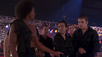 Movie still from “Roll Bounce” (2005), directed by Malcolm D. Lee – A group of young men standing next to each other; Medium shot, Over the shoulder angle