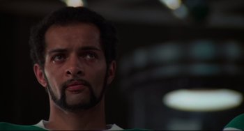 Movie still from “Rollerball” (1975), directed by Norman Jewison – A person with a beard looking at the camera; Close Up shot, Low angle