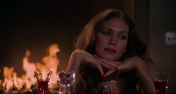 Movie still from “Rollerball” (1975), directed by Norman Jewison – A woman sitting in front of a fire; Close Up shot, Over the shoulder angle