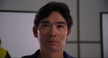 Movie still from “Rollerball” (1975), directed by Norman Jewison – A person wearing a black shirt; Close Up shot, Low angle