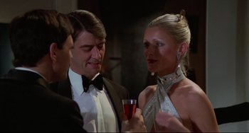 Movie still from “Rollerball” (1975), directed by Norman Jewison – A man and a woman holding a glass of wine; Close Up shot, Over the shoulder angle