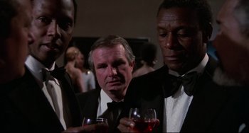 Movie still from “Rollerball” (1975), directed by Norman Jewison – A man in a tuxedo holding a glass of wine; Close Up shot, Low angle