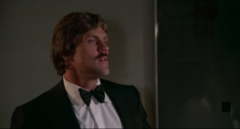 Movie still from “Rollerball” (1975), directed by Norman Jewison – A man wearing a tuxedo and a bow tie; Close Up shot, Low angle