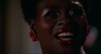 Movie still from “Rollerball” (1975), directed by Norman Jewison – A woman's face with bright red earrings; Close Up shot, Low angle