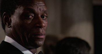 Movie still from “Rollerball” (1975), directed by Norman Jewison – A person wearing a suit and tie; Close Up shot, Low angle