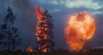 Movie still from “Rollerball” (1975), directed by Norman Jewison – A tree is burning in the middle of a field; Extreme Wide shot, Low angle