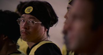 Movie still from “Rollerball” (1975), directed by Norman Jewison – A man with glasses and a hat is looking to his left; Close Up shot, Low angle