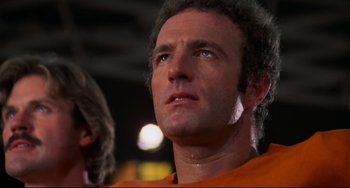 Movie still from “Rollerball” (1975), directed by Norman Jewison – A person wearing an orange shirt; Close Up shot, Low angle