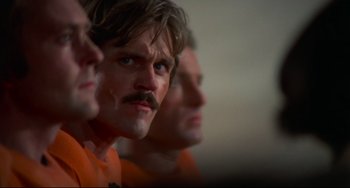 Movie still from “Rollerball” (1975), directed by Norman Jewison – A group of men standing next to each other; Close Up shot, Low angle