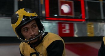 Movie still from “Rollerball” (1975), directed by Norman Jewison – A man in a yellow and black suit and helmet; Close Up shot, Low angle