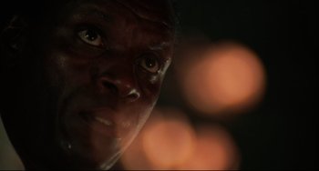 Movie still from “Rollerball” (1975), directed by Norman Jewison – A man's face in front of lights; Close Up shot, Low angle