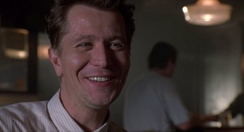 Movie still from “Romeo Is Bleeding” (1993), directed by Peter Medak – A person with a smile on his face; Close Up shot, Low angle