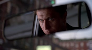 Movie still from “Romeo Is Bleeding” (1993), directed by Peter Medak – A person looking out of a car window; Close Up shot, Low angle