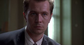 Movie still from “Romeo Is Bleeding” (1993), directed by Peter Medak – A person wearing a suit and tie; Close Up shot, Low angle