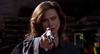 Movie still from “Romeo Is Bleeding” (1993), directed by Peter Medak – A woman is holding a gun in her hand; Close Up shot, Low angle