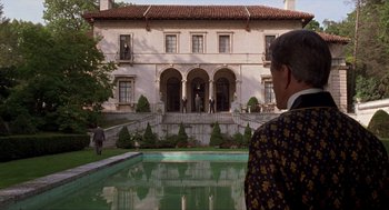 Movie still from “Romeo Is Bleeding” (1993), directed by Peter Medak – A man standing in front of a large white building; Extreme Wide shot, Over the shoulder angle