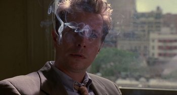 Movie still from “Romeo Is Bleeding” (1993), directed by Peter Medak – A person wearing a suit and tie; Close Up shot, Over the shoulder angle