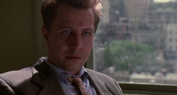 Movie still from “Romeo Is Bleeding” (1993), directed by Peter Medak – A person wearing a suit and tie; Close Up shot, Over the shoulder angle