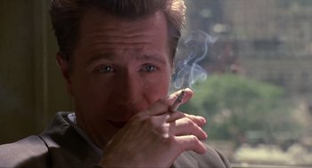 Movie still from “Romeo Is Bleeding” (1993), directed by Peter Medak – A person smoking a cigarette; Close Up shot, Over the shoulder angle